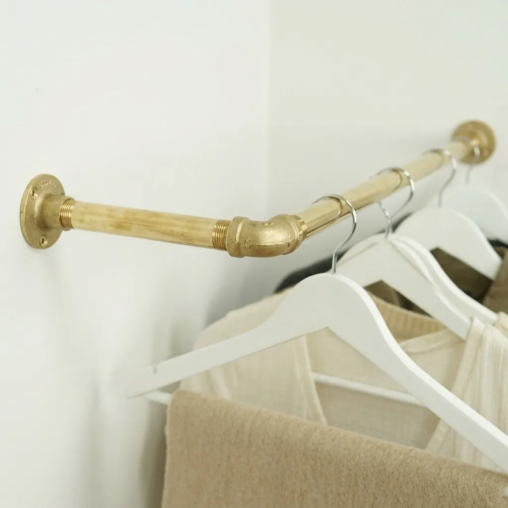 Brass corner clothes rail in a walk-in closet