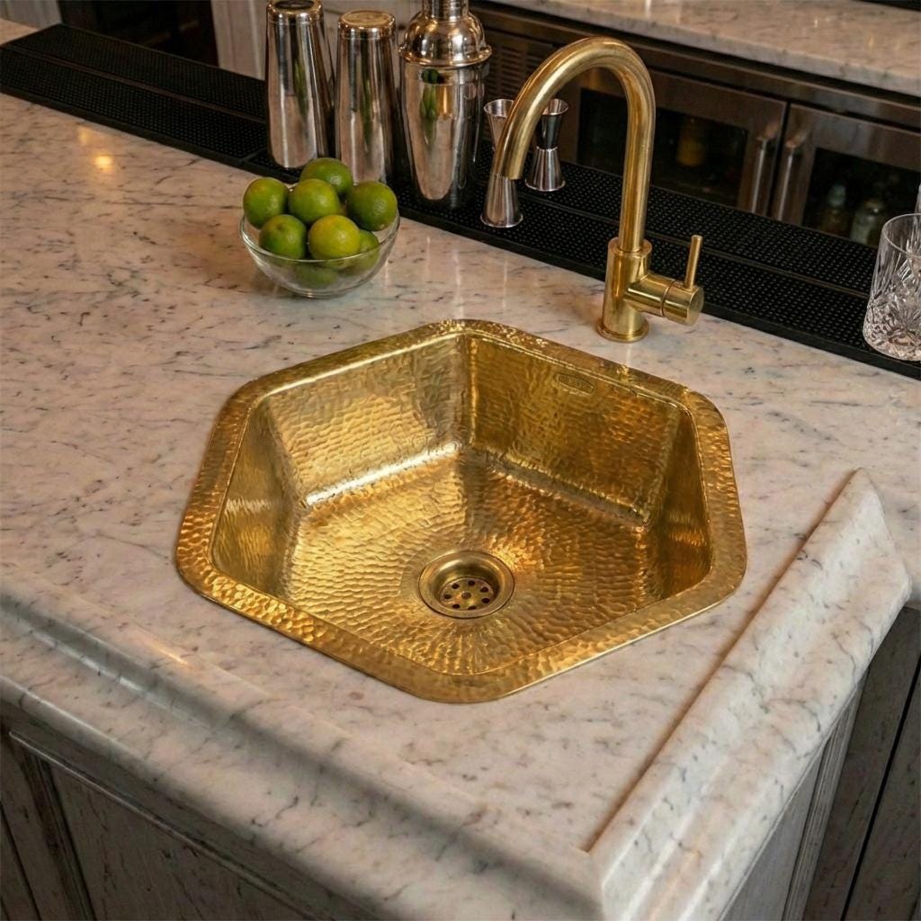 Handcrafted hammered brass bar sink installed in a marble countertop
