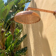 Outdoor Copper Rain Shower Head with Wall Mounted Arm and Tropical Garden Setting