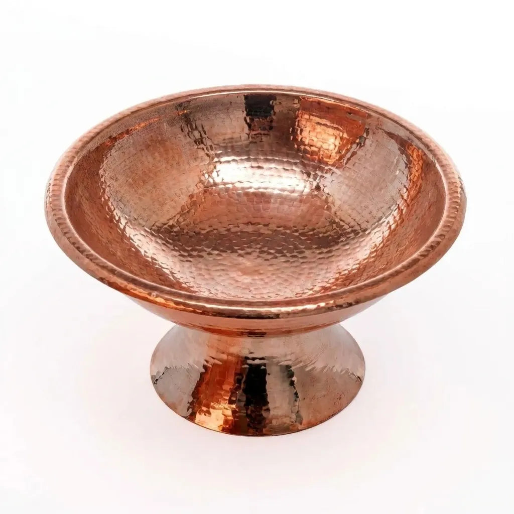 Artisan solid copper centerpiece bowl with hammered texture displaying apples, grapes, and pomegranates on a wooden table.