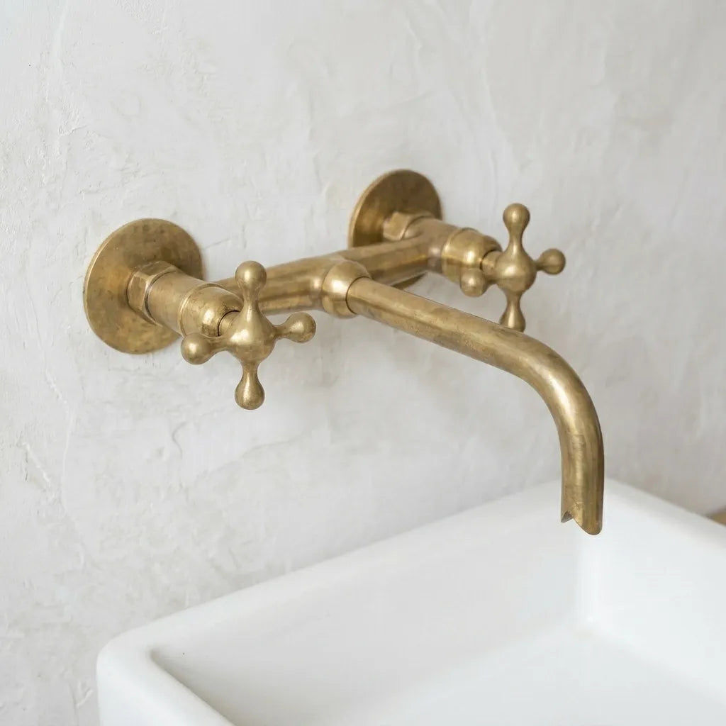 Solid brass two handle wall mounted sink mixer featuring a warm living finish and classic bridge style construction