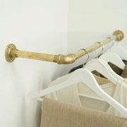 Custom corner wardrobe hanging rod made from unlacquered solid brass.