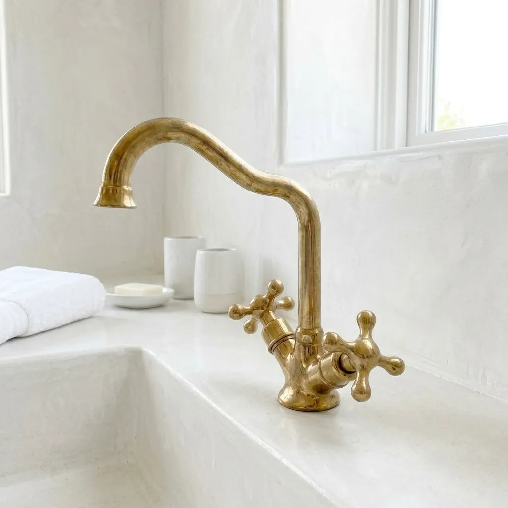 Luxury brass bathroom sink faucet with timeless curved silhouette and dual handle water controls
