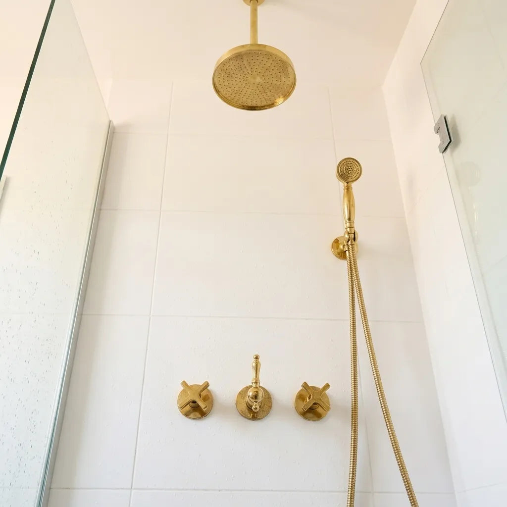 Solid brass ceiling-mounted rainfall shower featuring concealed controls and matching hand shower.