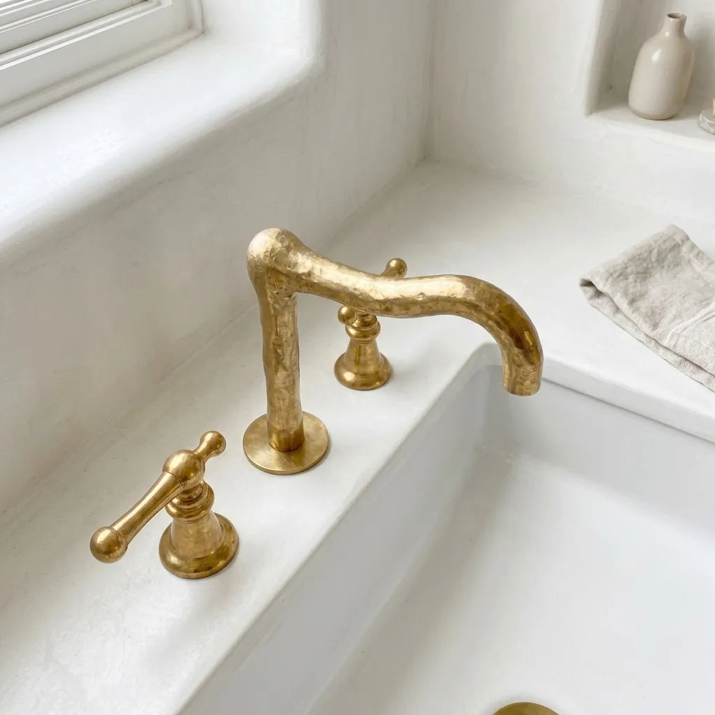 Solid brass bathroom mixer tap featuring an organic hammered texture and widespread deck mount configuration