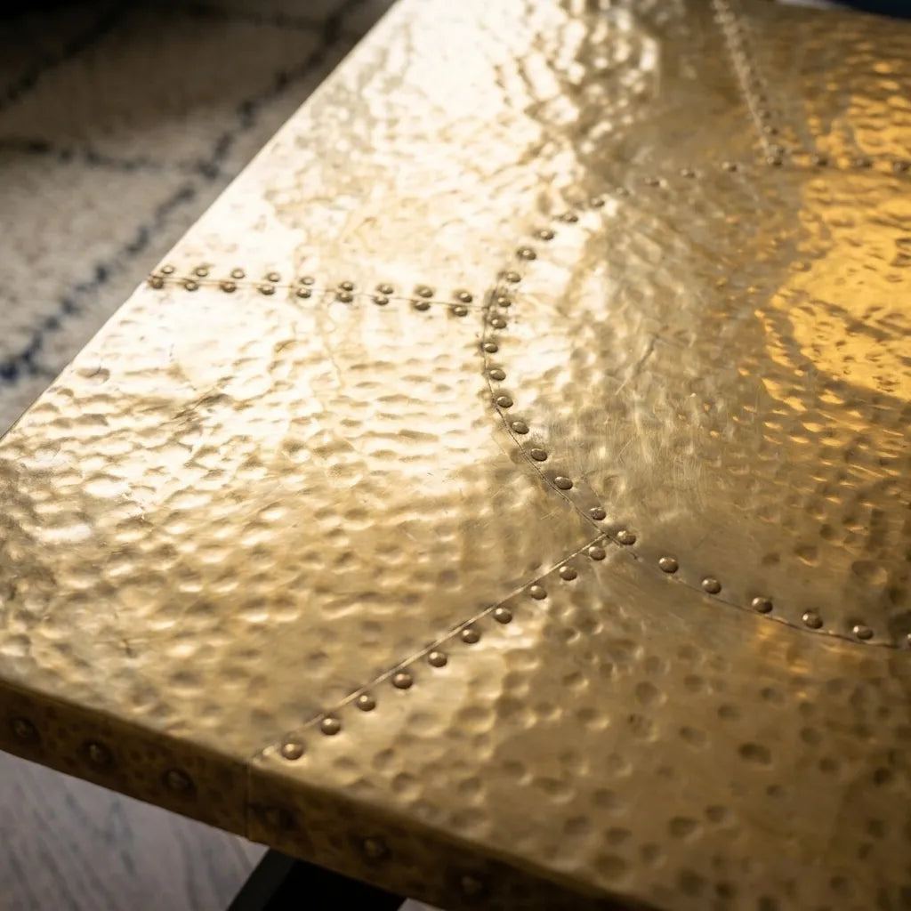 Modern coffee table featuring a polished brass hammered finish