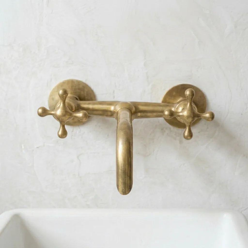 Luxury brass wall faucet installed above a countertop basin, combining vintage inspired detailing with modern functionality