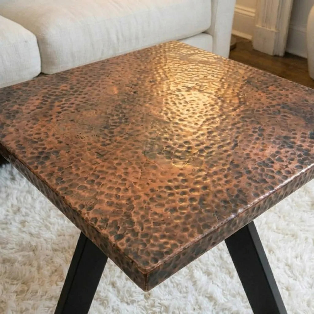 Modern living room table with aged copper surface and black legs