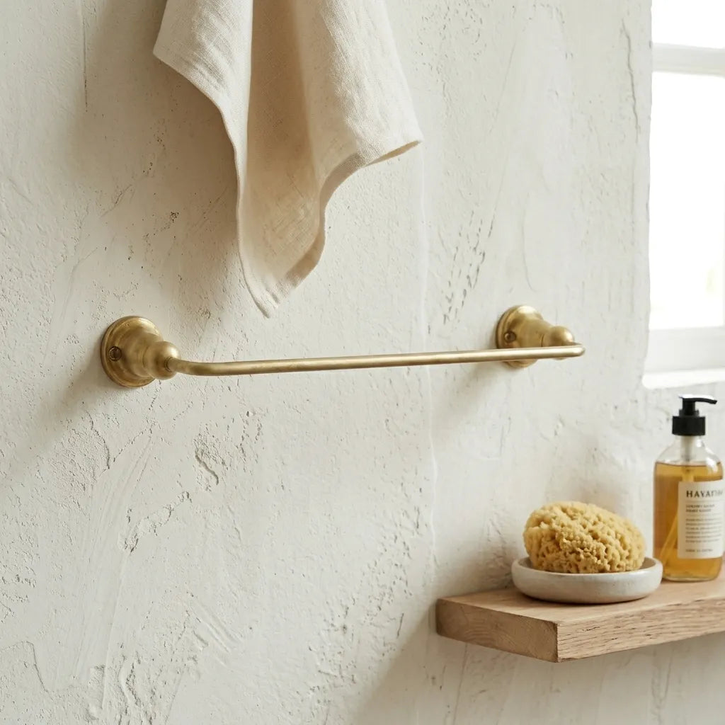Solid brass bathroom towel rack with minimalist curved detailing and a naturally aging unlacquered surface