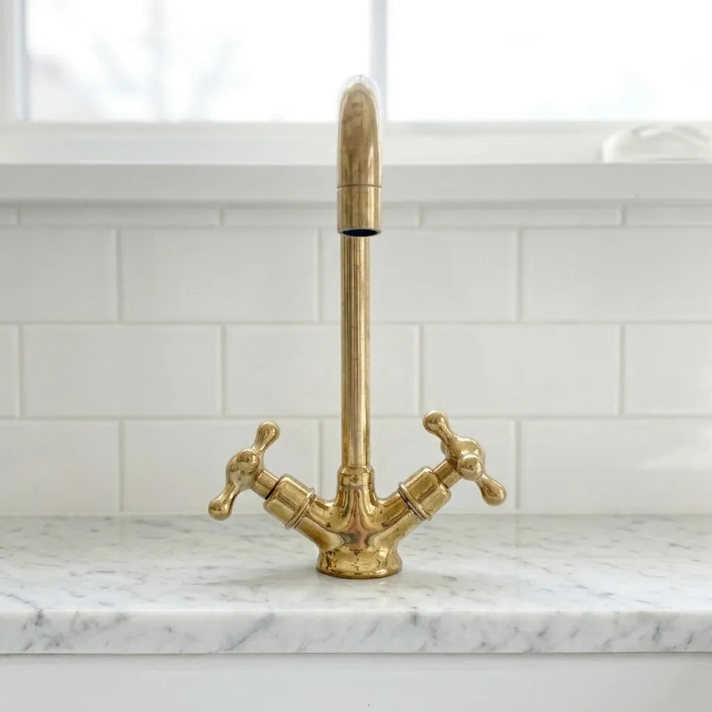 Luxury brass bathroom tap with elevated rectangular neck and polished metal finish on a marble countertop