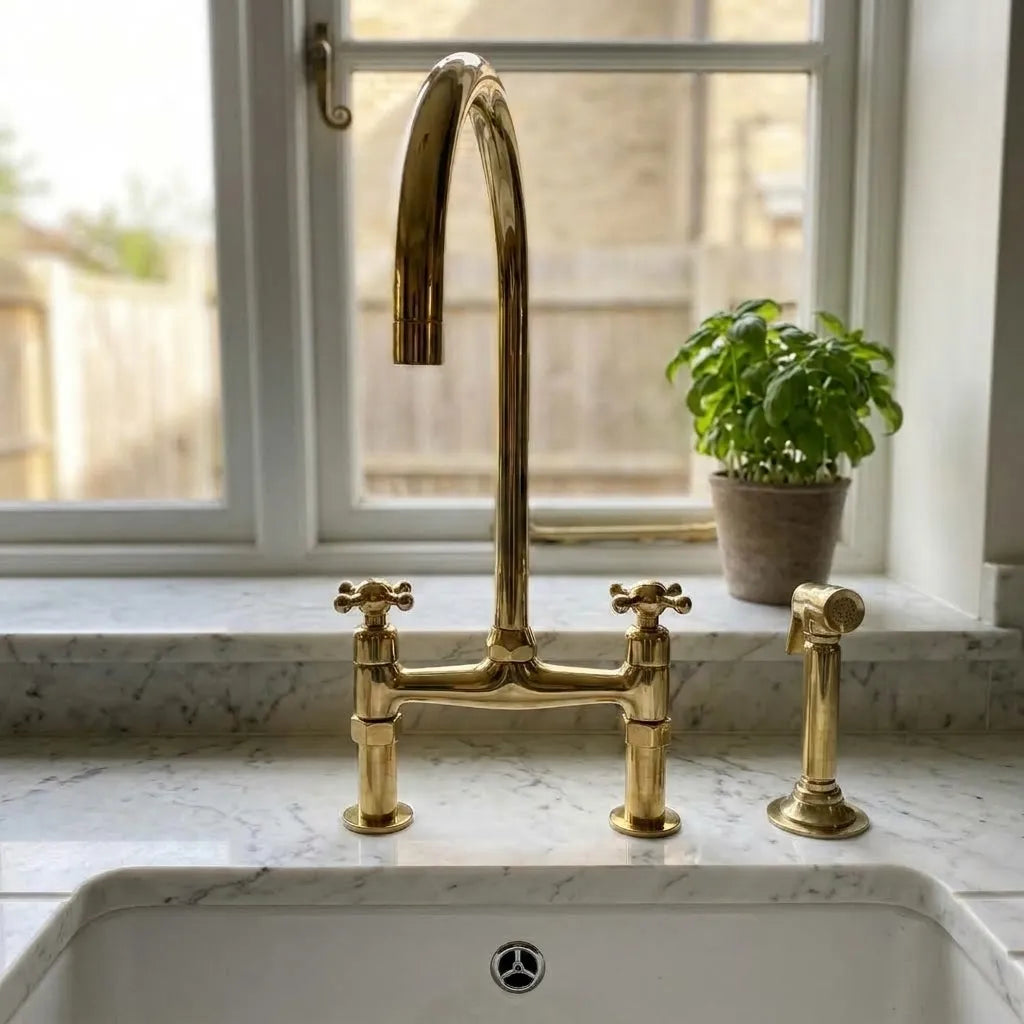 Unlacquered brass kitchen tap with exposed bridge body and handheld side spray