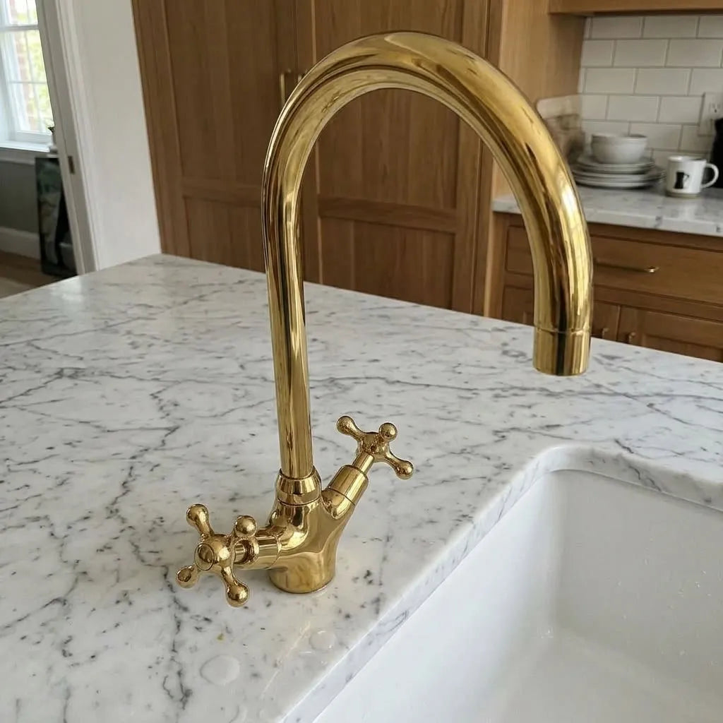 Brass monoblock kitchen faucet with sculpted cross handles and curved spout