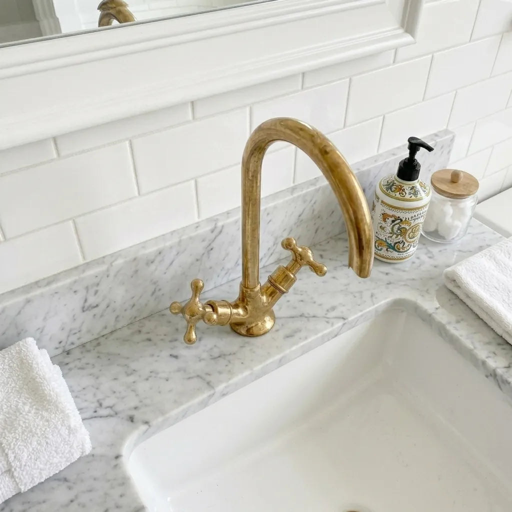 Vintage style brass vanity mixer tap with polished finish and high arc neck in a bright white bathroom setting
