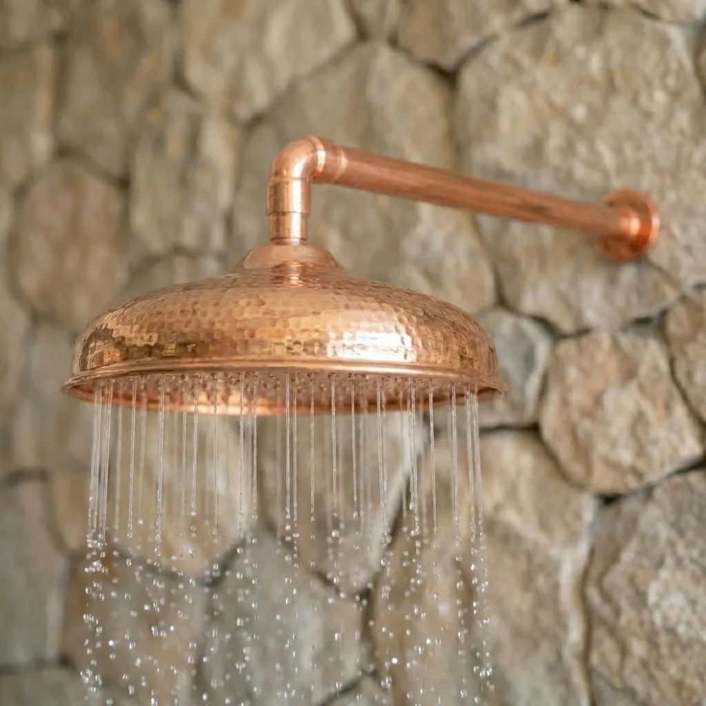 Rustic Copper Rain Shower Head Installed on Natural Stone Wall with Water Flowing