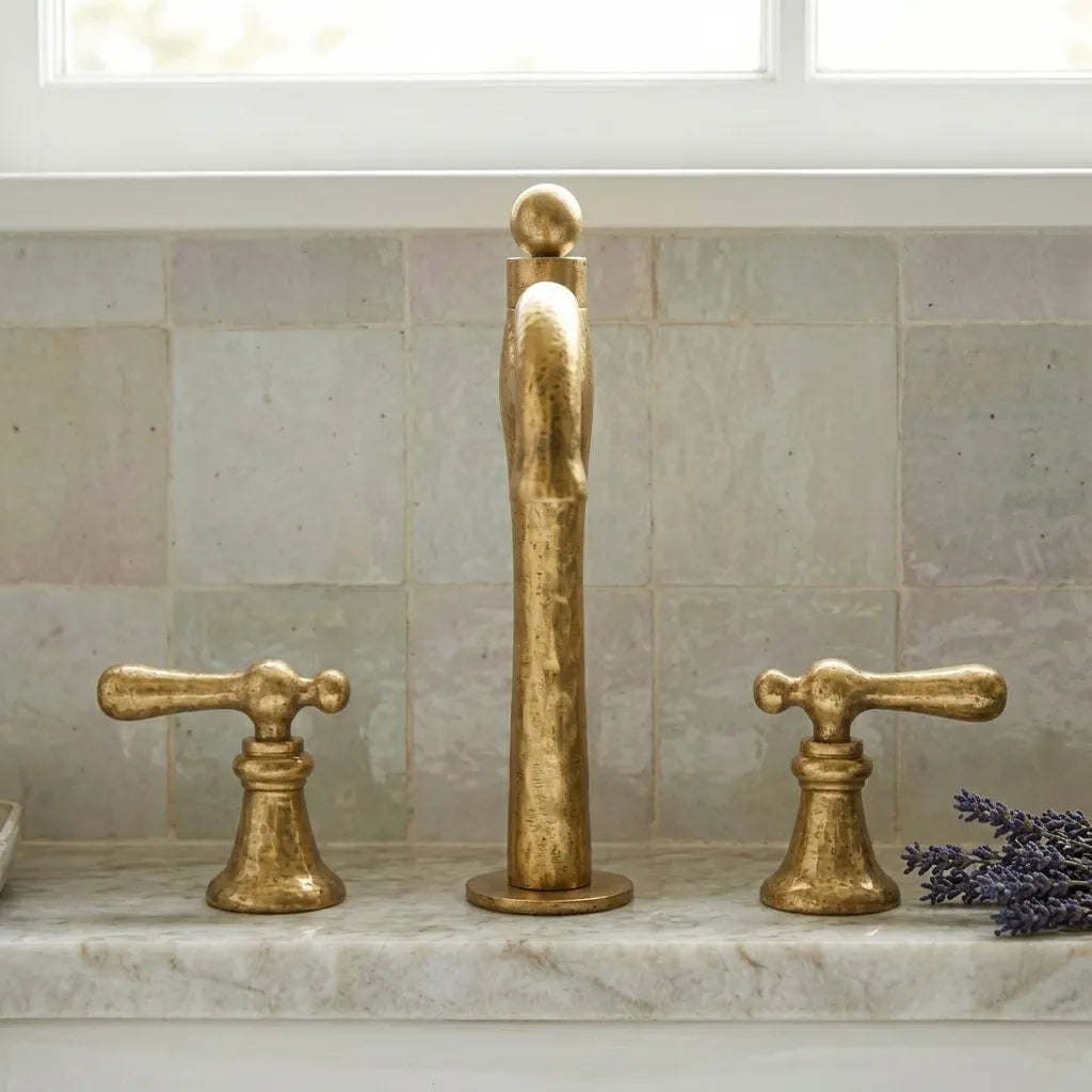 Luxury hammered brass vanity mixer with elevated arched spout and handcrafted detailing beside a ceramic basin