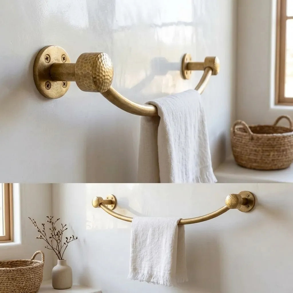 Curved solid brass towel bar with hammered round end caps shown in a bright bathroom interior