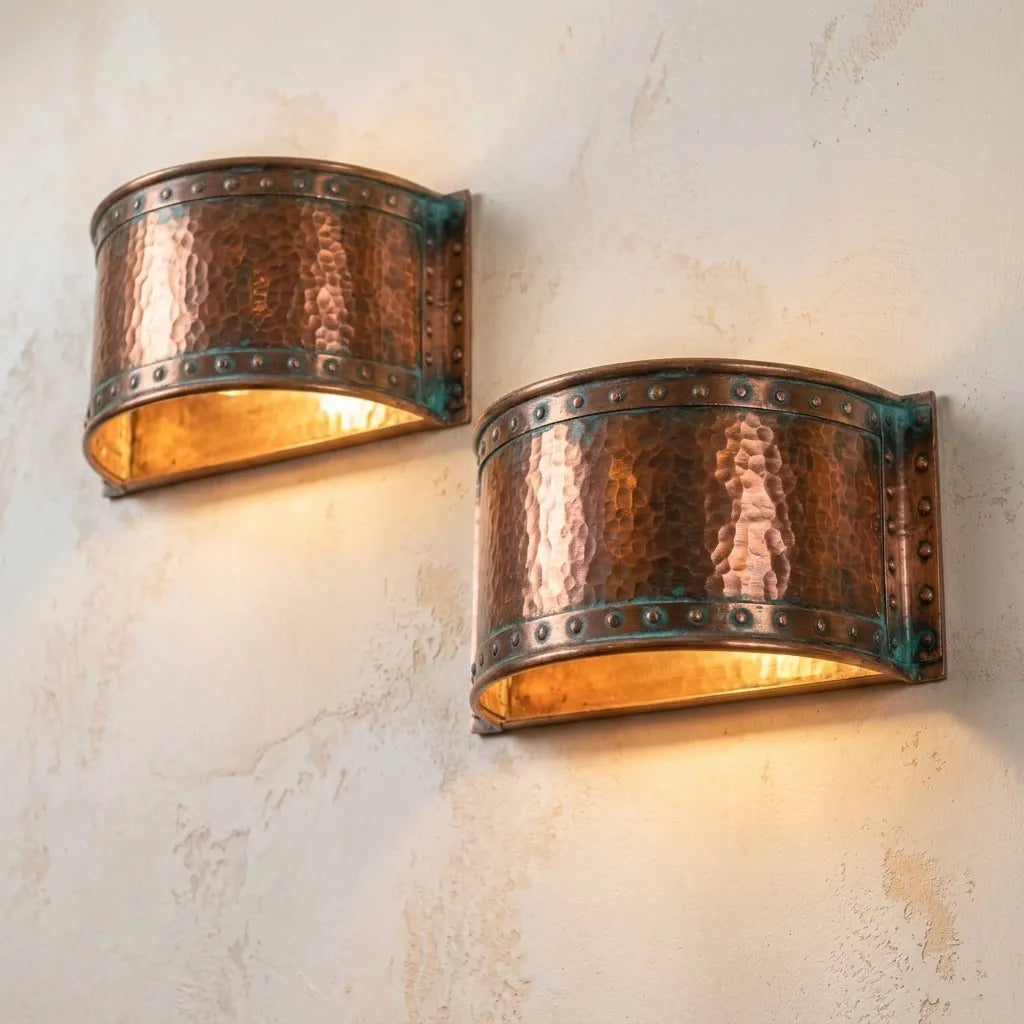 Decorative hammered copper wall fixture with handcrafted verdigris patina and curved design.