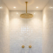 Ceiling mounted solid brass rain shower head in modern tiled bathroom