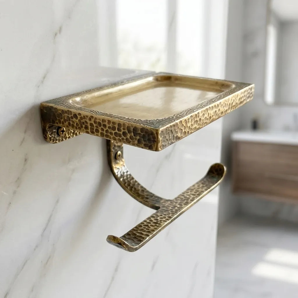 Hammered brass toilet paper holder with integrated storage shelf, handcrafted for elegant bathroom organization and daily convenience