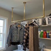 Ceiling mounted solid brass clothes rail in modern laundry room