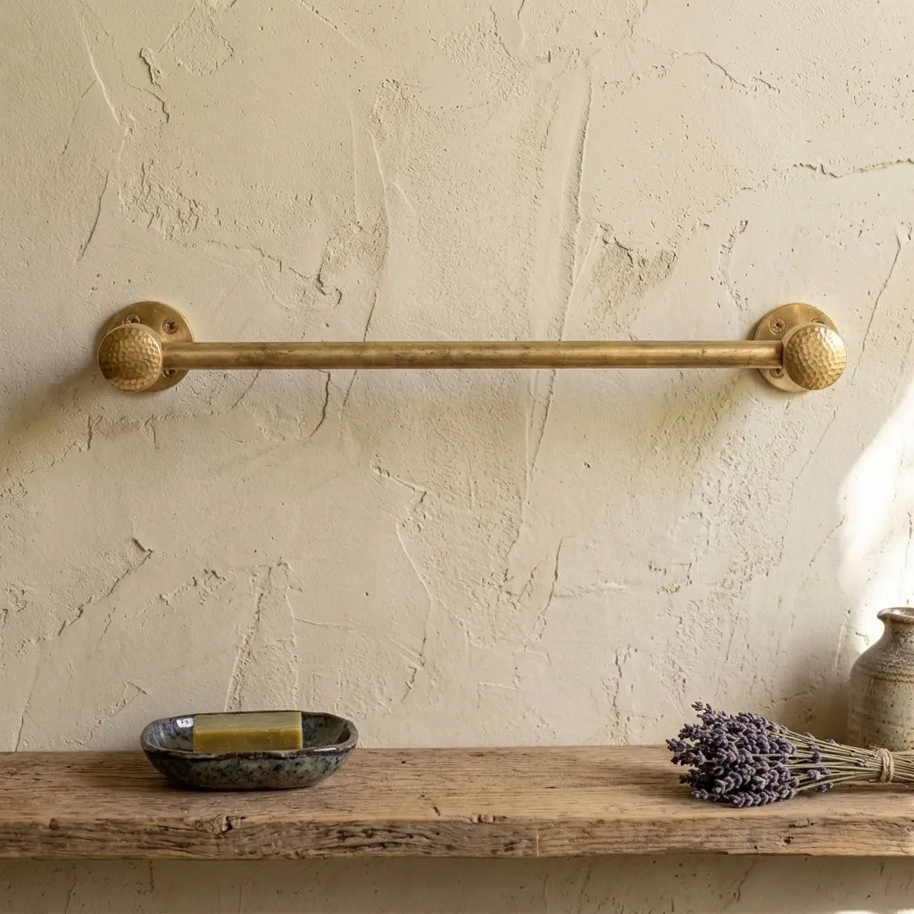 Handcrafted brass towel rail with decorative hammered finials for luxury bathrooms