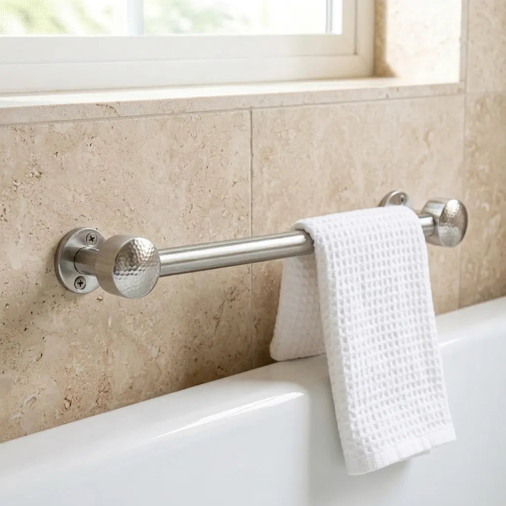 Polished chrome towel rail mounted on a natural stone bathroom wall