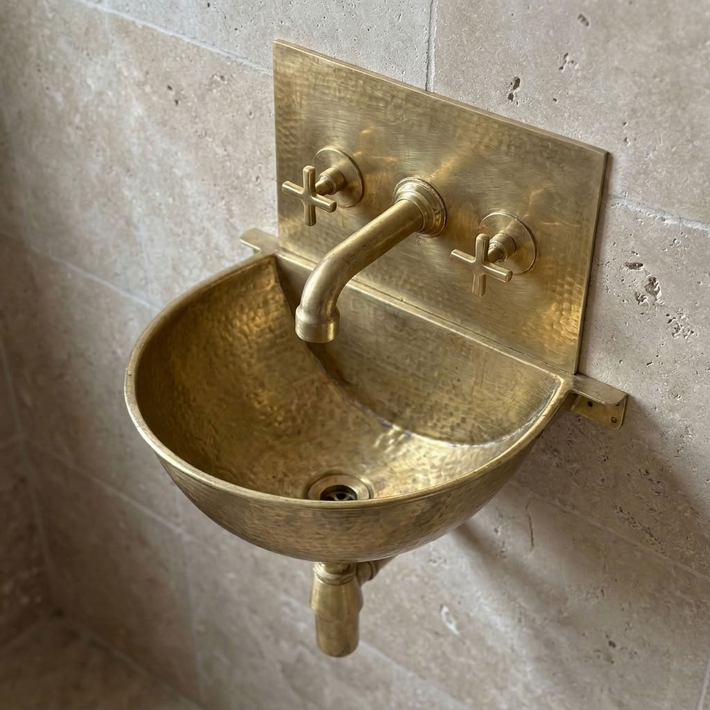 Hand hammered brass wall mount sink with cross handle wall faucet on travertine wall