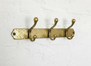 Handmade hammered brass wall-mounted coat rack with three double hooks for entryway, bathroom, or mudroom organization.