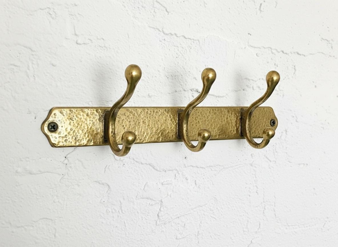 Handmade hammered brass wall-mounted coat rack with three double hooks for entryway, bathroom, or mudroom organization.