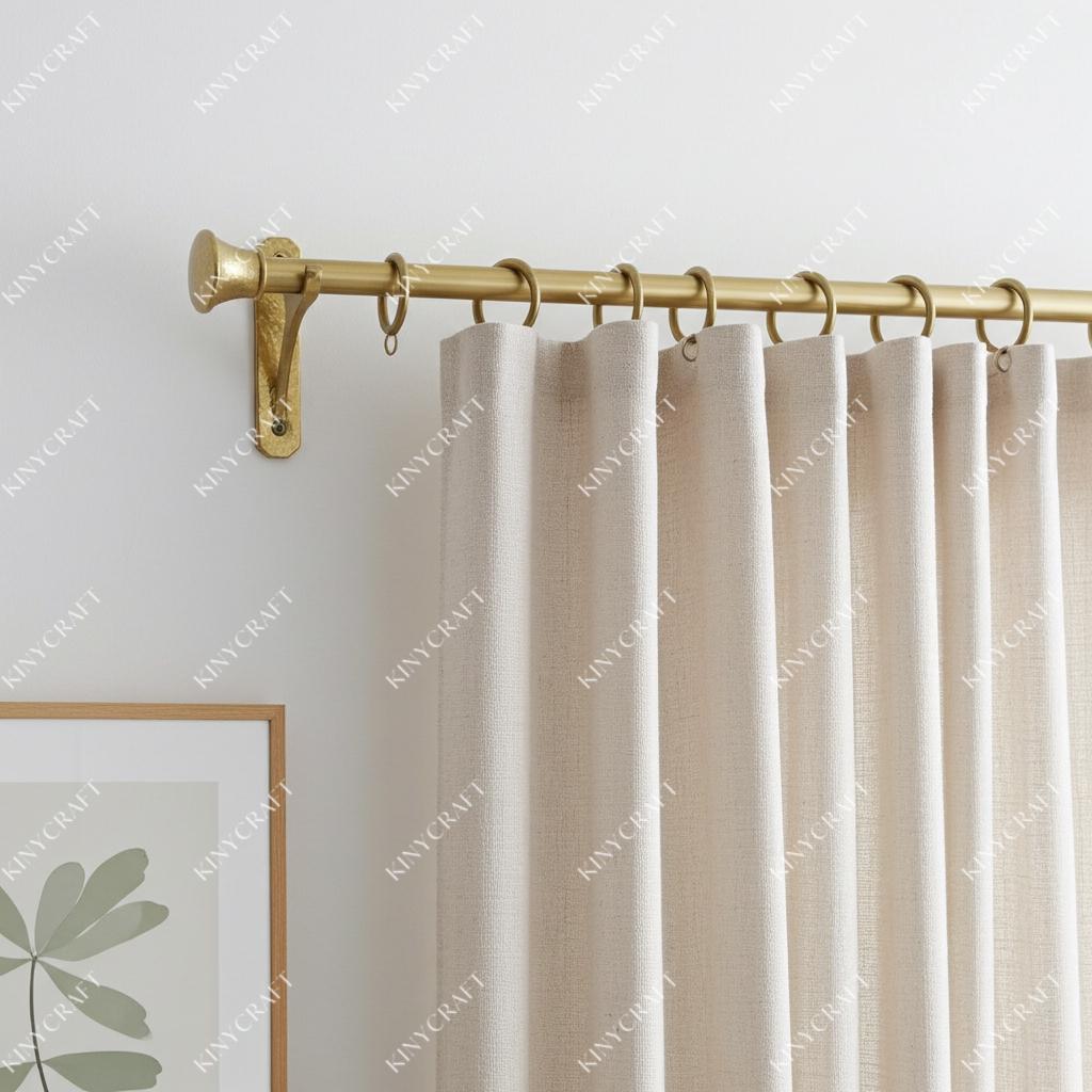 Solid brass curtain rod with handcrafted hammered brackets and decorative finials, installed with linen curtains.