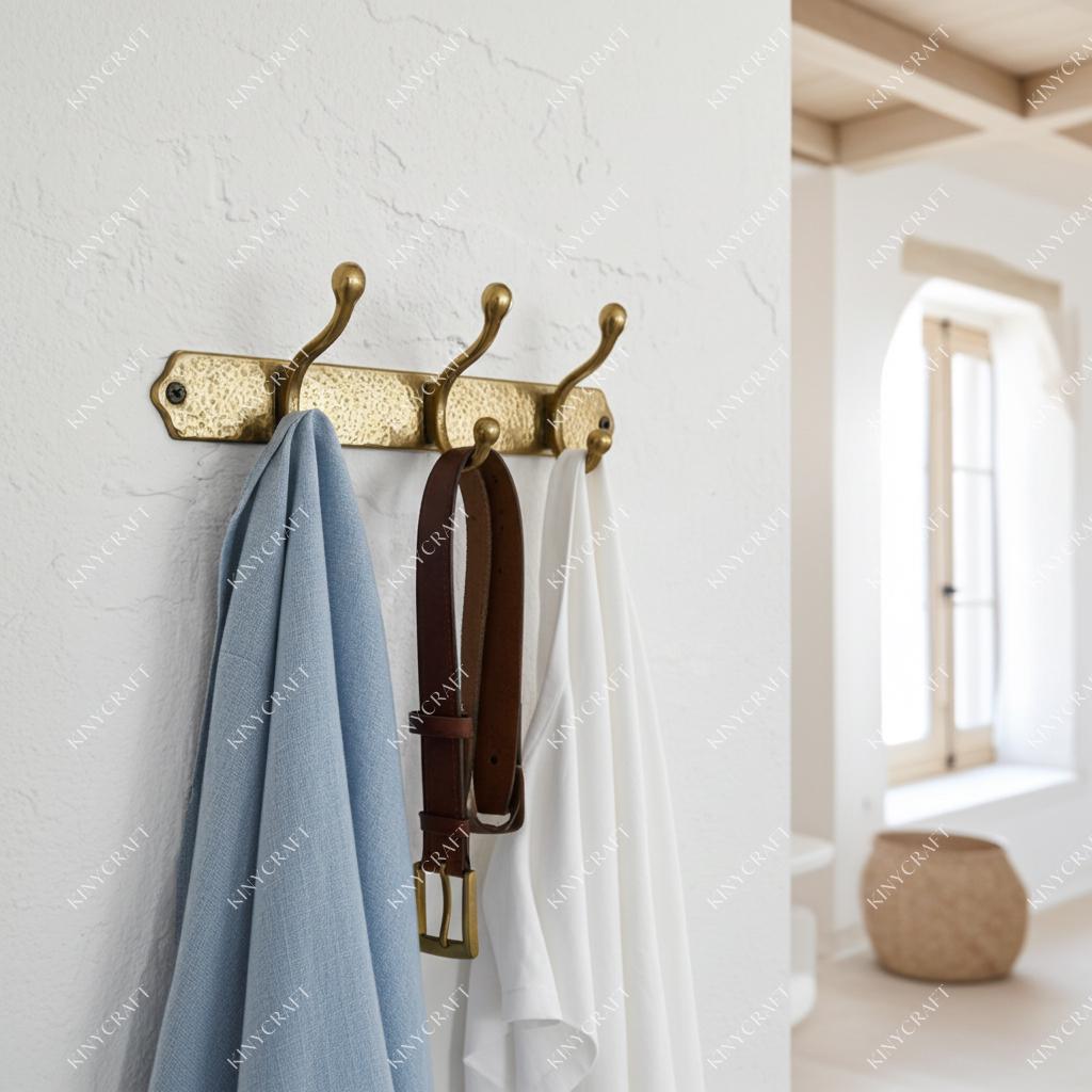 Rustic hammered brass coat hook rail featuring three dual-purpose hooks for farmhouse and vintage interiors.