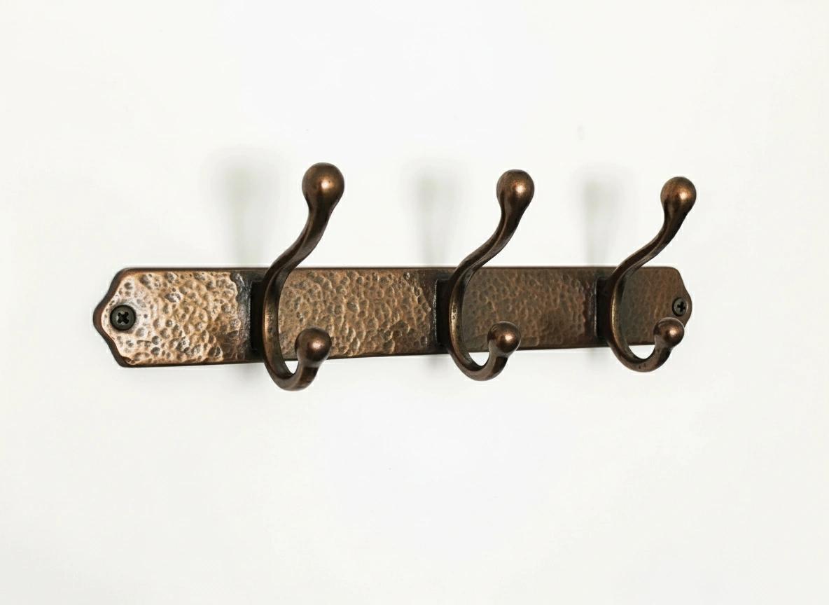 Vintage-style hammered brass wall coat rack with three double hooks for organizing jackets, towels, robes, and accessories.