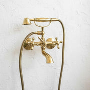 Unlacquered brass wall mount bathtub faucet with handheld shower