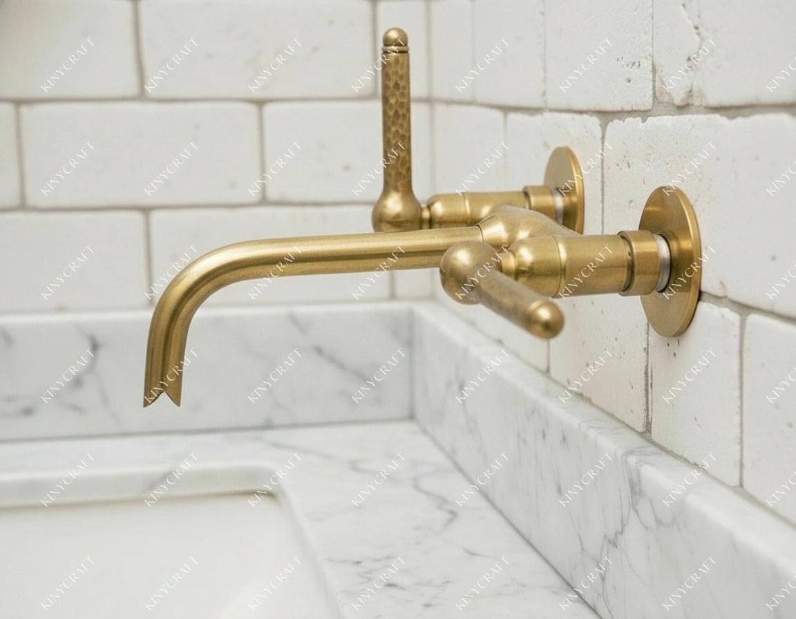 Vintage-inspired brass wall faucet with hammered handle detailing and elegant spout.