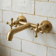 Unlacquered brass wall mount bathroom faucet with cross handles