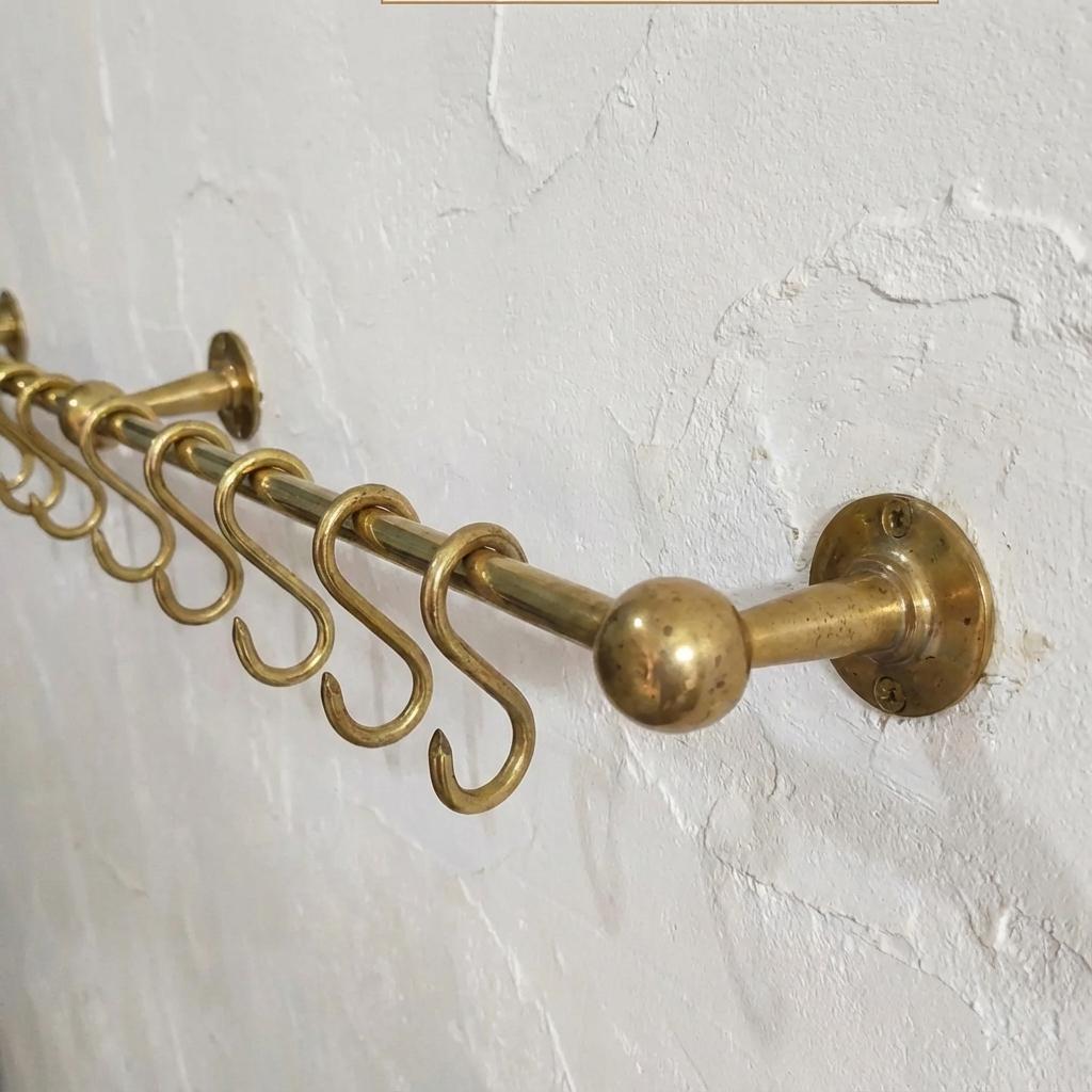 Solid brass kitchen utensil rail with hanging hooks for wall mounted storage