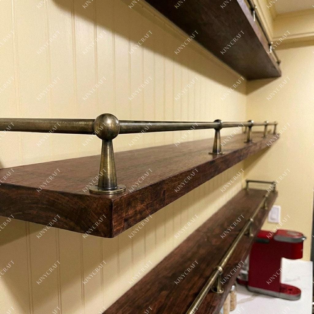 Decorative brass shelf guard with ball finials installed on open wooden shelving.