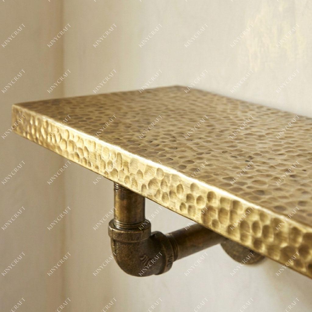 Floating brass display shelf with hammered finish for bathroom, kitchen, or living room storage.