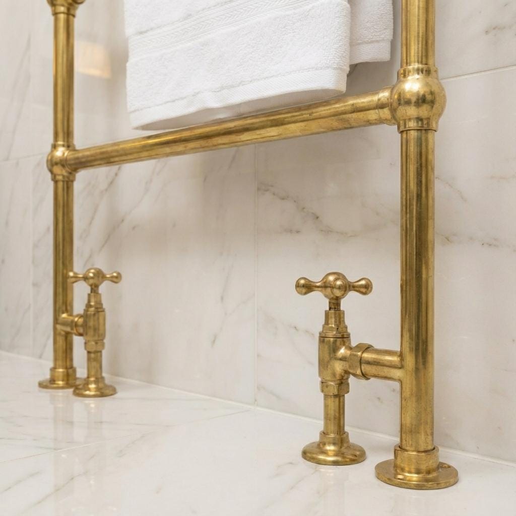 Handcrafted heated brass towel rail installed on a marble bathroom countertop.